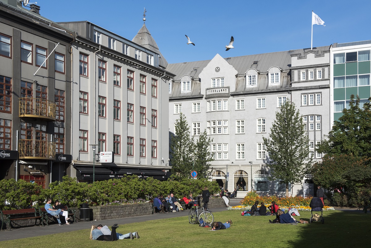 Austurvollur plein in Reykjavik, waar mensen 's zomers genieten van het zonnetje.