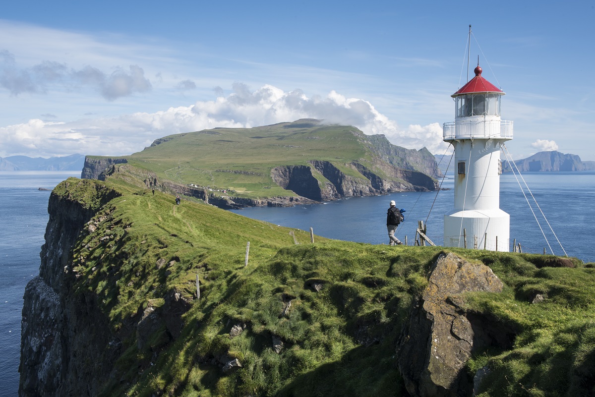 Wandelaars bij de vuurtoren op Mykines tijdens een reis op de Faroer eilanden.