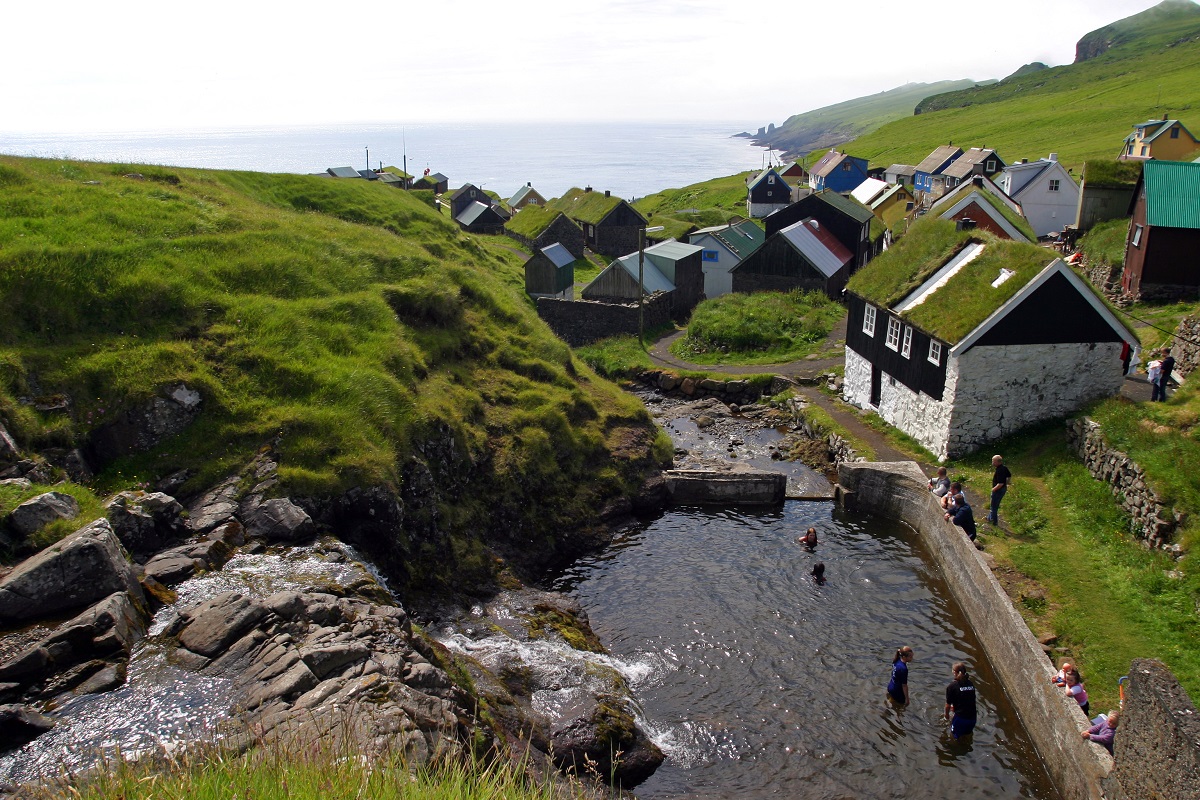 Mensen zwemmen in de rivier in het dorpje op Mykines, Faroer.