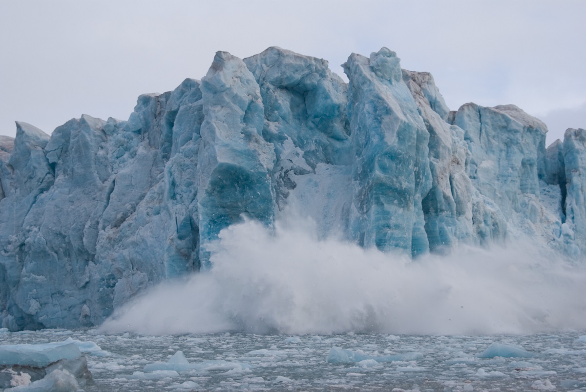 Afkalvende ijsbrokken vanaf de gletsjer in Spitsbergen storten in het water.