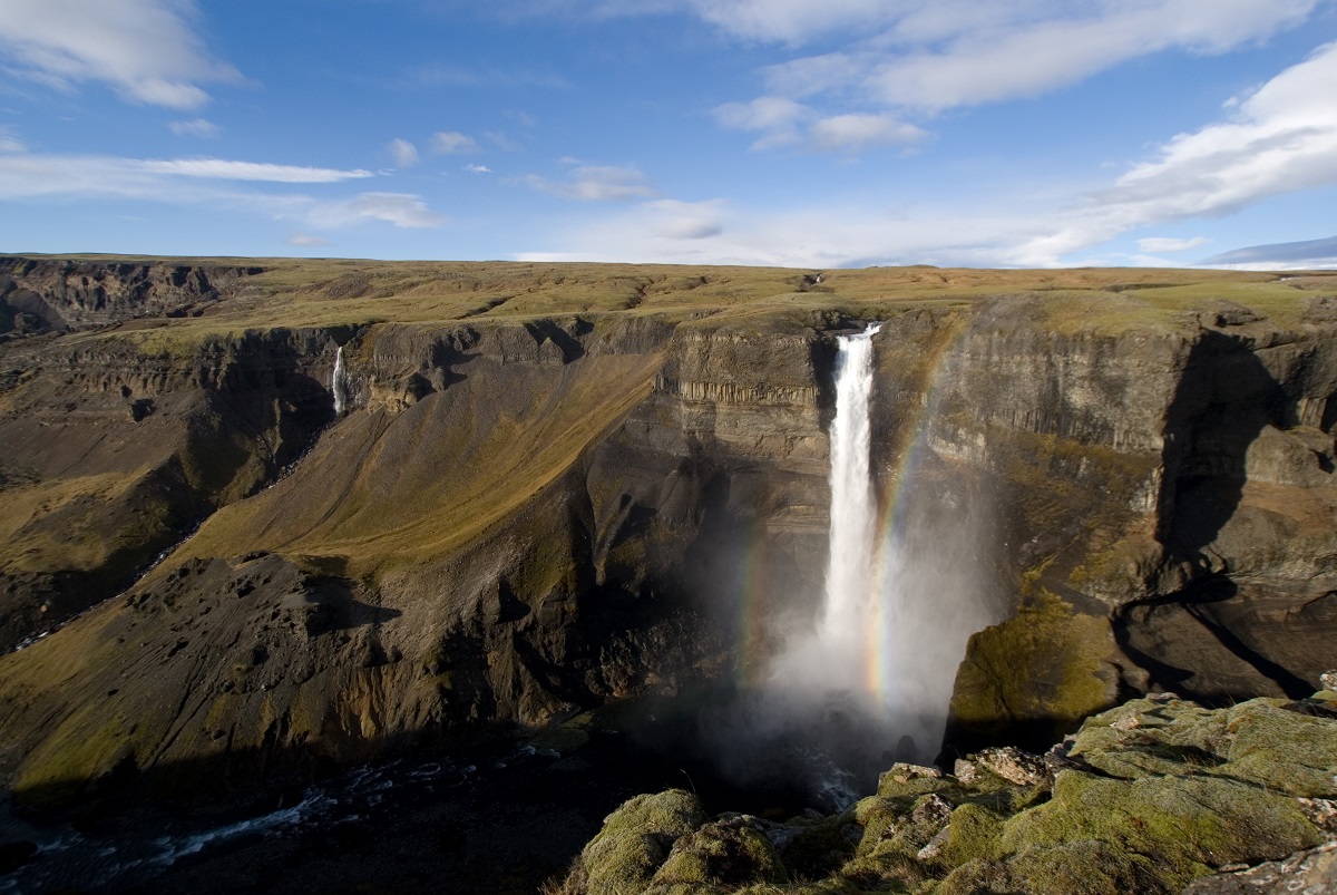 De mooie Haifoss waterval met een regenboog in zuid IJsland.