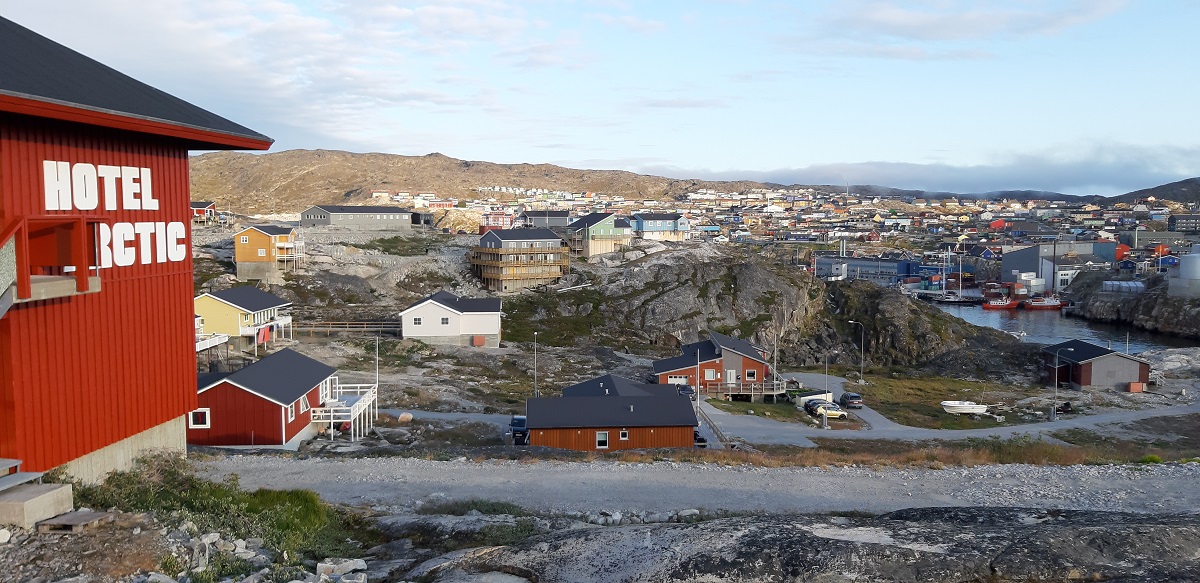 Het rode gebouw van hotel Arctic in west Groenland met uitzicht op het dorpje Ilulissat.