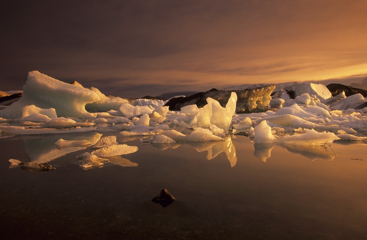 Prachtige oranje gloed tijdens de zonsondergang over het ijsbergenmeer Jokulsarlon, in zuidoost IJsland.