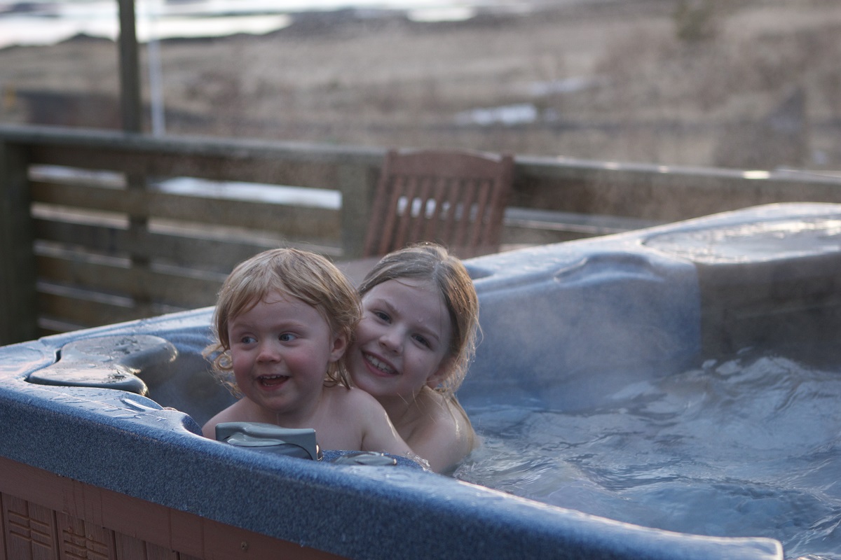 Kinderen spelen samen in de hot pot van Vogur Lodge, in west IJsland.