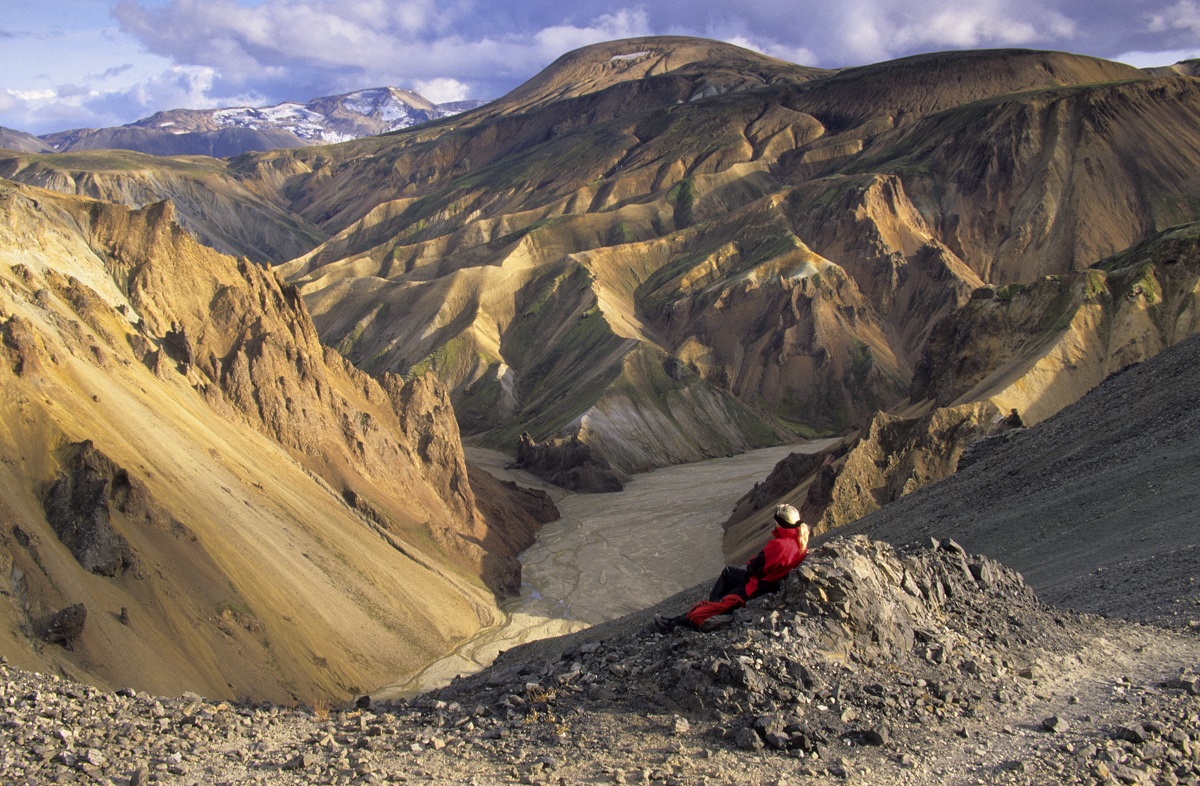 Wandelaar geniet van het uitzicht op de vallei van Landmannalaugar, in de hooglanden van IJsland, met kleurrijke bergen.