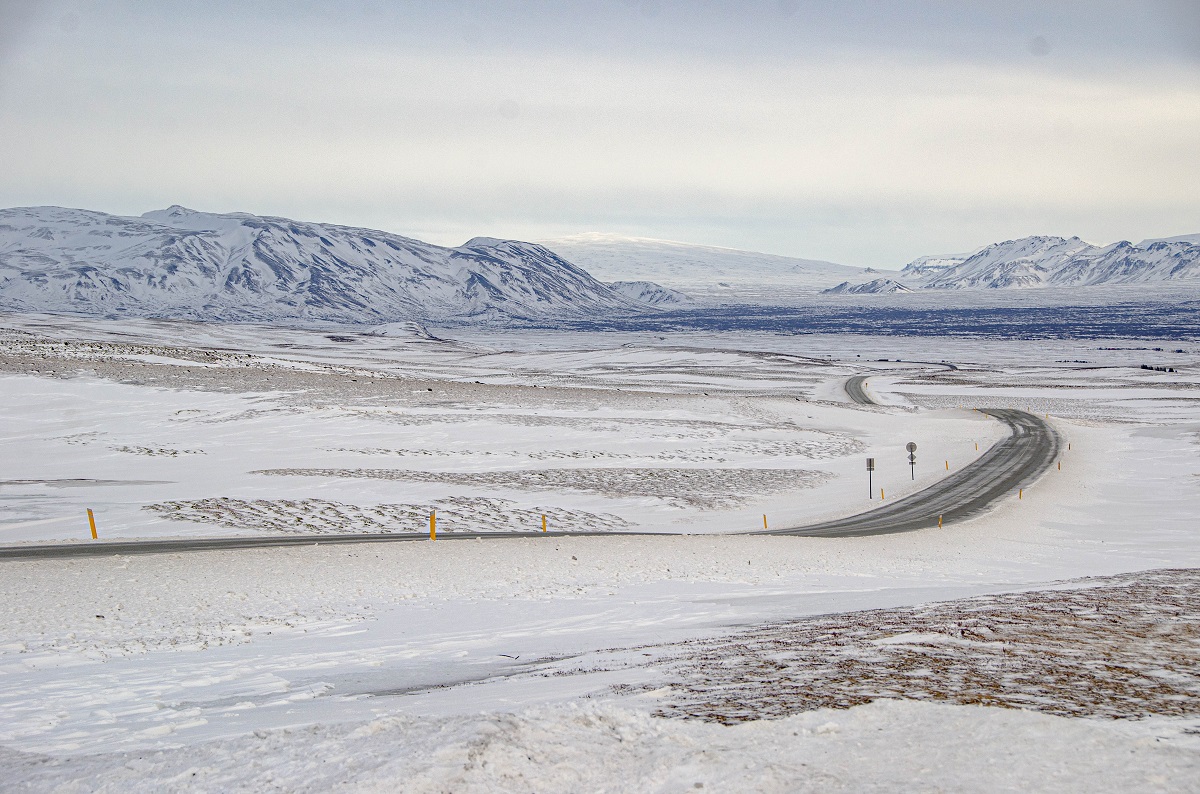 Een wit, winters landschap op Snaefellsnes, in west IJsland, met bergen op de achtergrond.