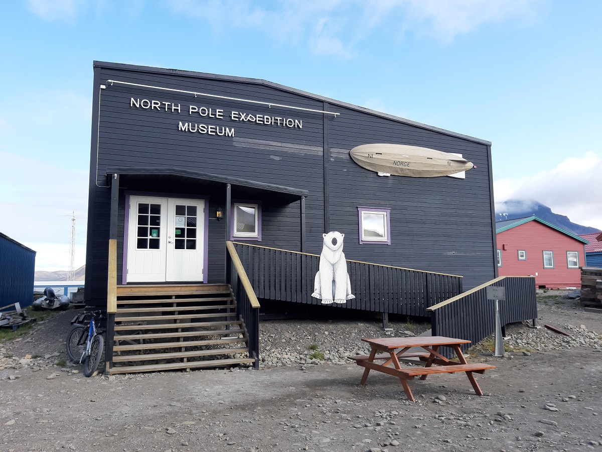 Het zwarte gebouw met een plaatje van een ijsbeer op het hek is een museum in Longyearbyen, Spitsbergen.