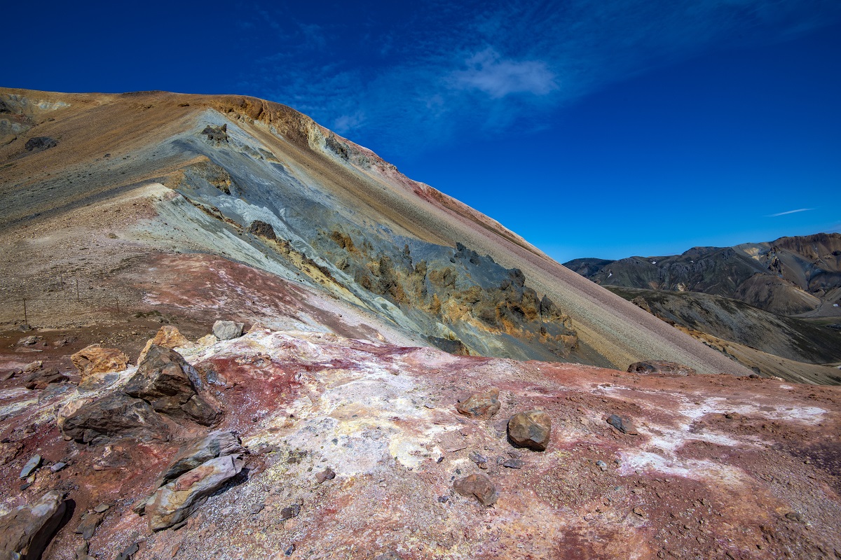 Rood en blauw gekleurde heuvel in Landmannalaugar, de hooglanden van IJsland, met een helder blauwe lucht.