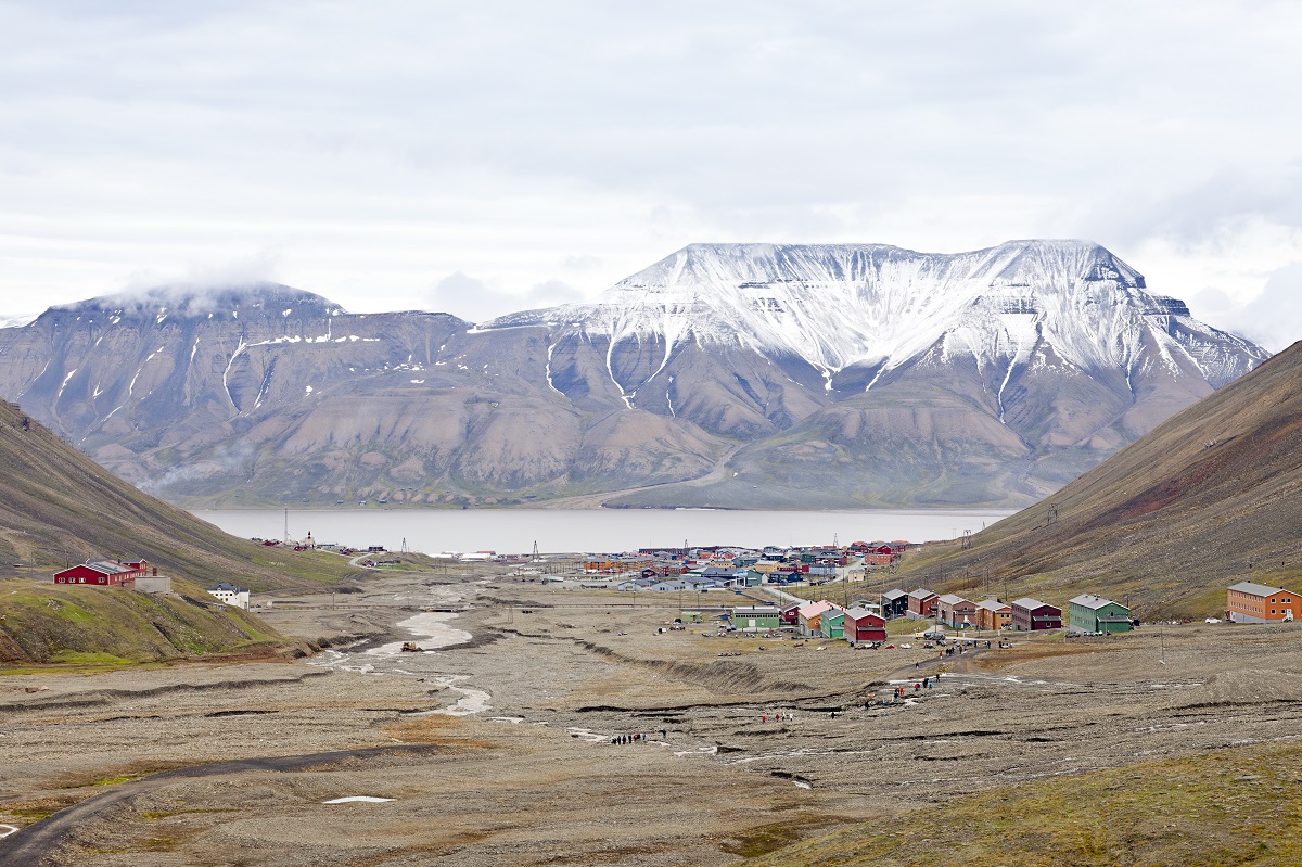 Uitzicht over het vrolijk gekleurde stadje Longyearbyen in Spitsbergen met besneeuwde bergen op de achtergrond.