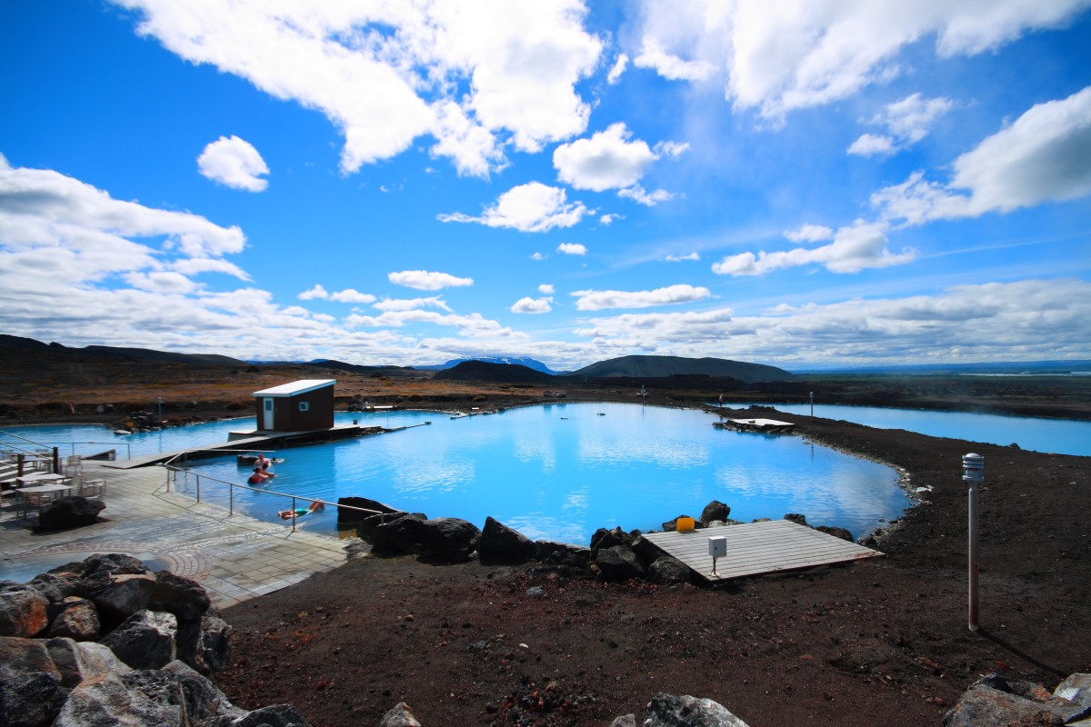 Het melkblauwe water bij Myvatn Batsh reflecteerd de blauwe lucht.