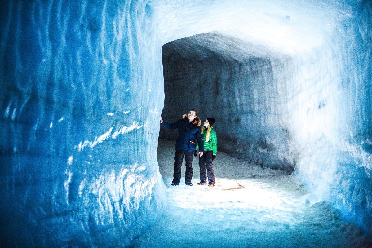 2 reizigers staan in de ijstunnel van Into The Glacier bij Husafell.