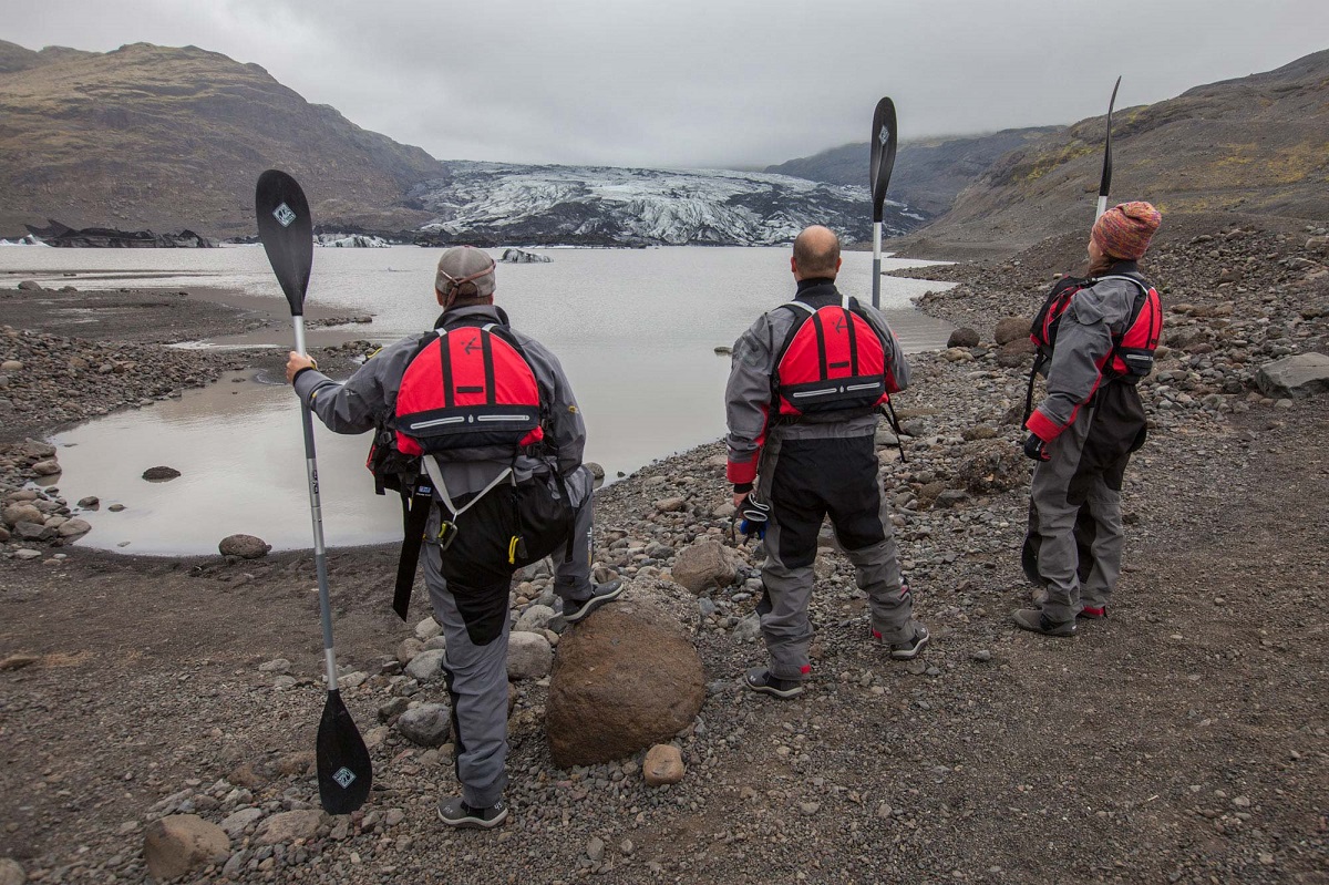 Drie reizgers staan klaar voor het kajakken bij Solheimajokull.