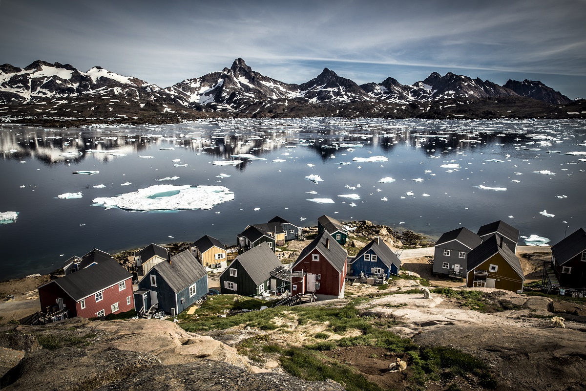 Huisjes in Tasiilaq aan de rand van Kong Oscars Havn met de Polheim berg op de achtergrond.