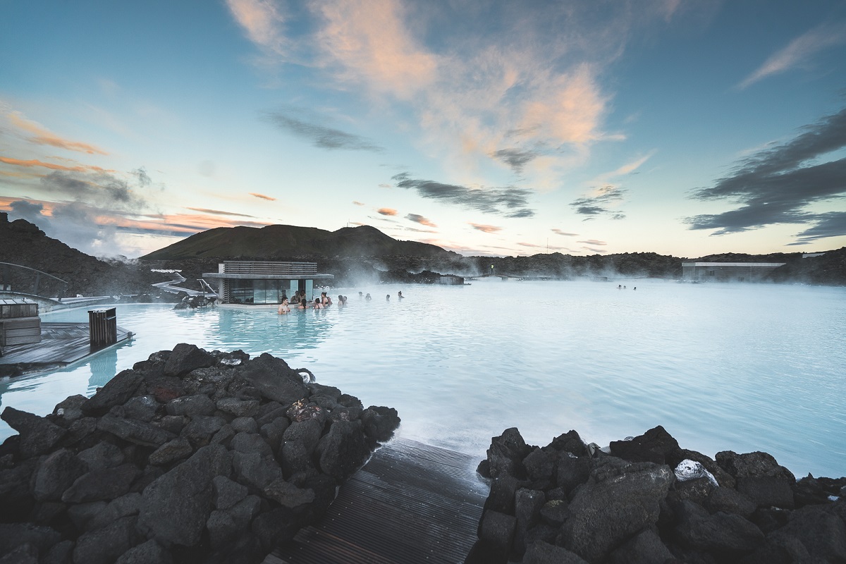 Stoom stijgt op uit de Blue Lagoon, waarin mensen aan het zwemmen zijn.