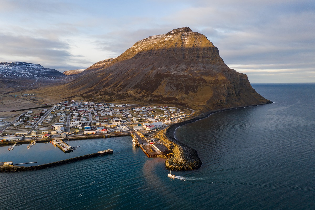 Een boot vaart de haven binnen van het dorpje Bólungarvik gelegen in de Westfjorden van IJsland. 