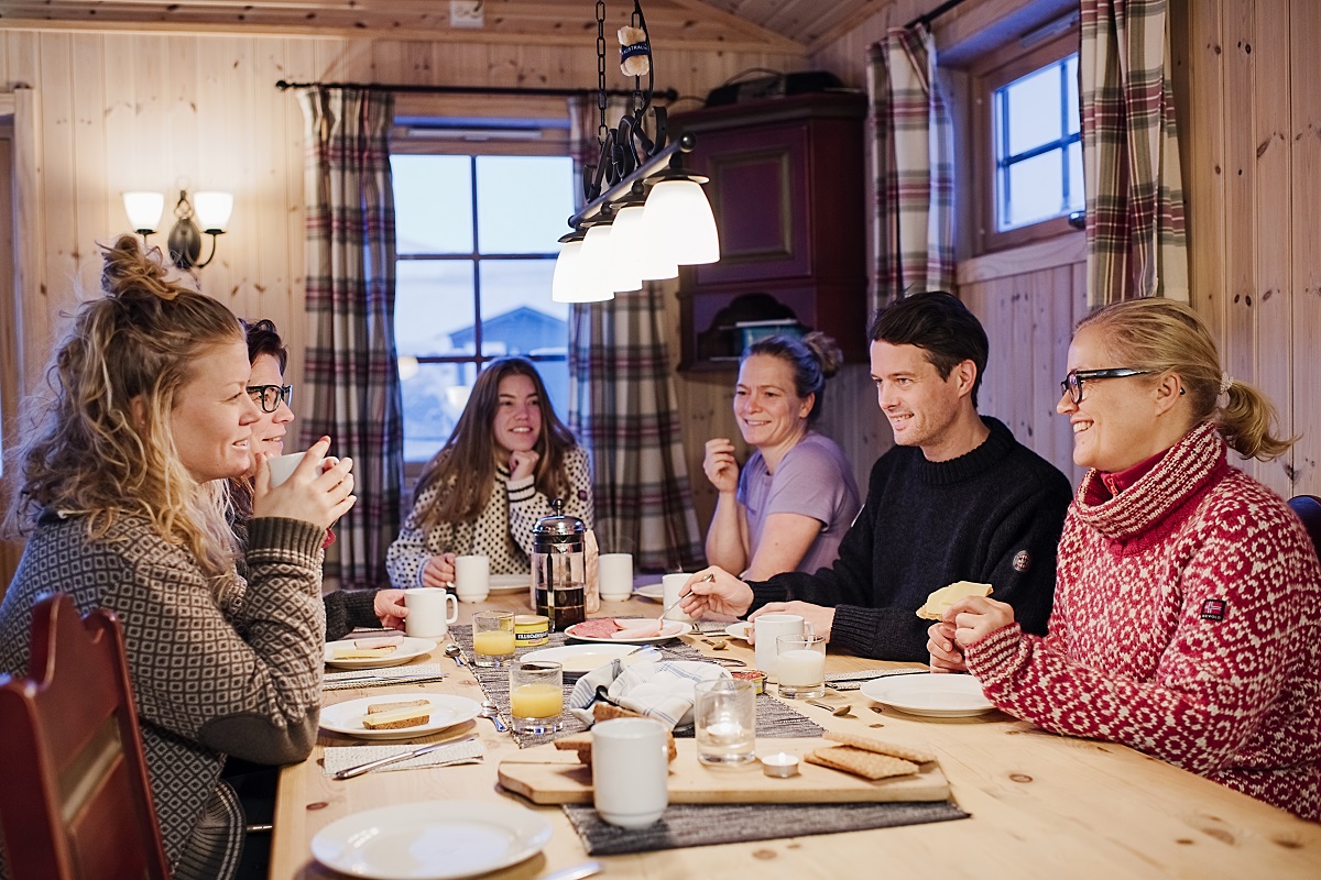 Vijf reizigers gezellig aan het diner in de Juva Hut.