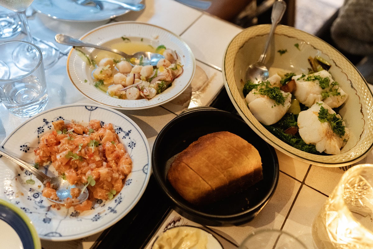 Borden met verschillende visgerechten in een restaurant op de Faroer eilanden. De tafel is gedekt.