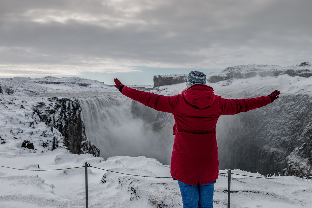De dettifoss waterval gelegen in het noorden van IJsland. Reiziger staat voor het winterse en besneeuwde landschap van deze krachtige waterval.