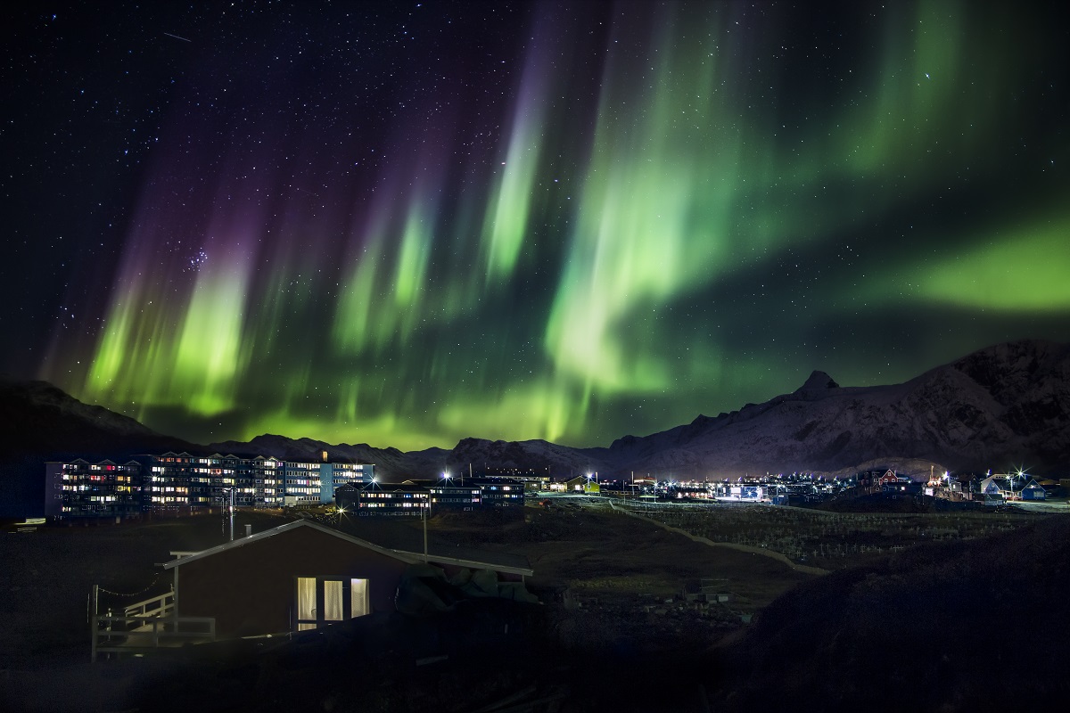 Dansend kleurrijk noorderlicht strekt zich uit over Sisimiut in het westen van Groenland.