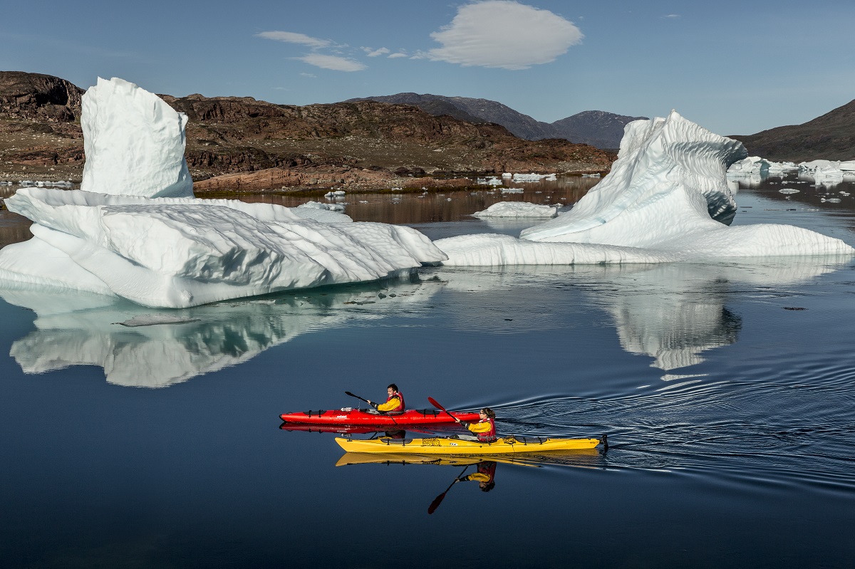 Kajakkers tussen de grote ijsbergen in het Sermilik fjord in het zuiden van Groenland.