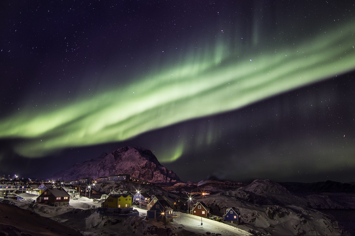 Het groene noorderlicht schijnt boven het dorpje Sisimiut in het westen van Groenland.