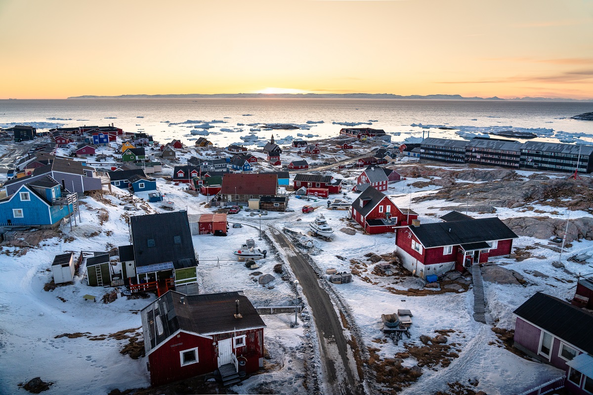 Zonsondergang te zien bij de kleurrijke stad Ilulissat in de winter, gelegen in het westen van Groenland.