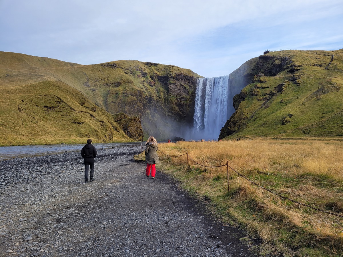 Reizigers lopen naar de Skogafoss water in het zuidwesten van IJsland.