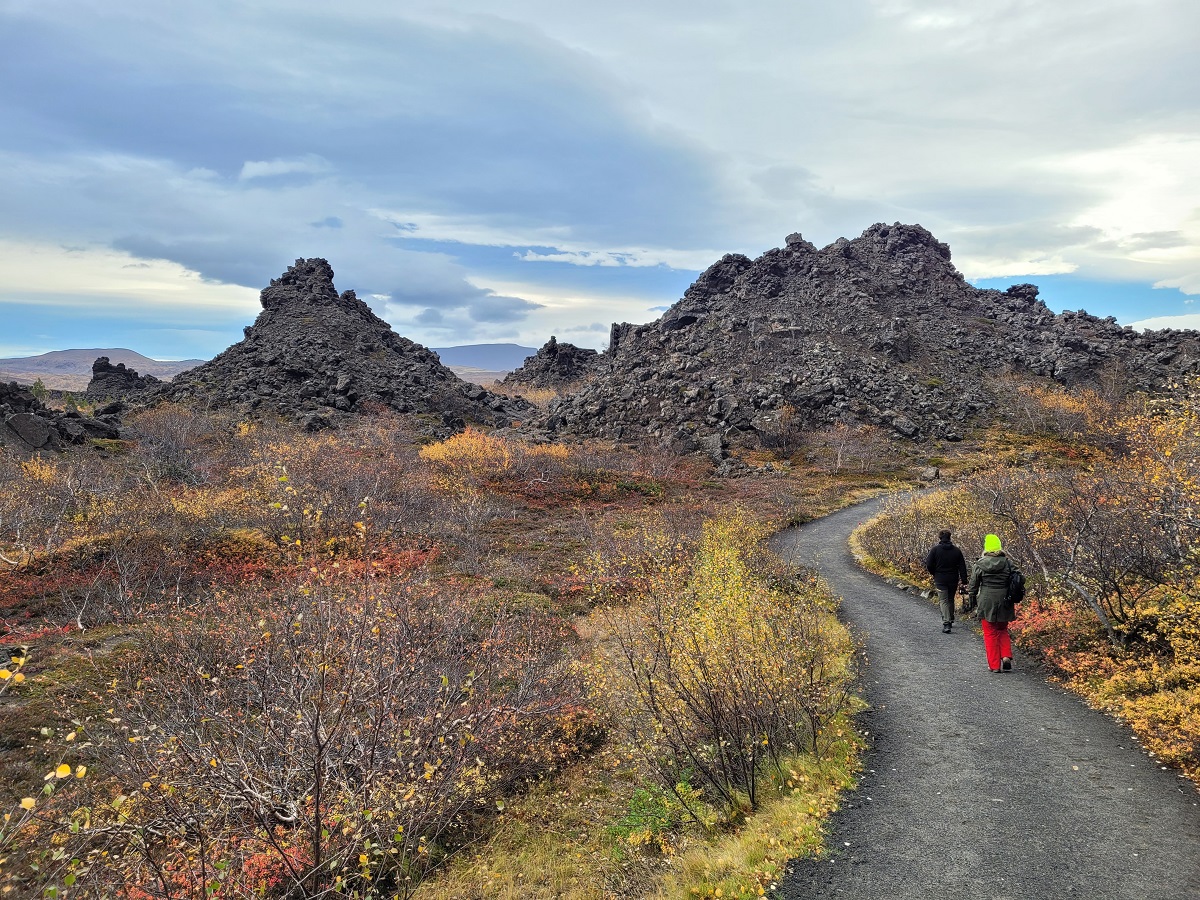 Reizigers wandelen in Dimmuborgir in een herfstlandschap in de buurt van het Myvatn meer.