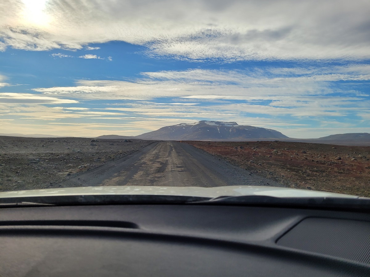 Uitzicht vanuit de auto op de Kjolur hooglandenroute in IJsland met een berg op de achtergrond.