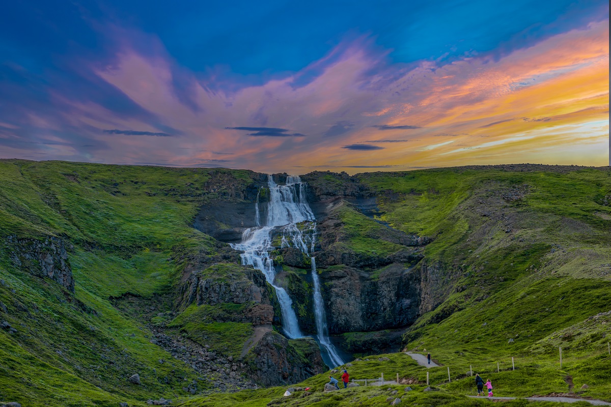 De Rjukandi waterval bij zonsondergang in een groen zomerlandschap.