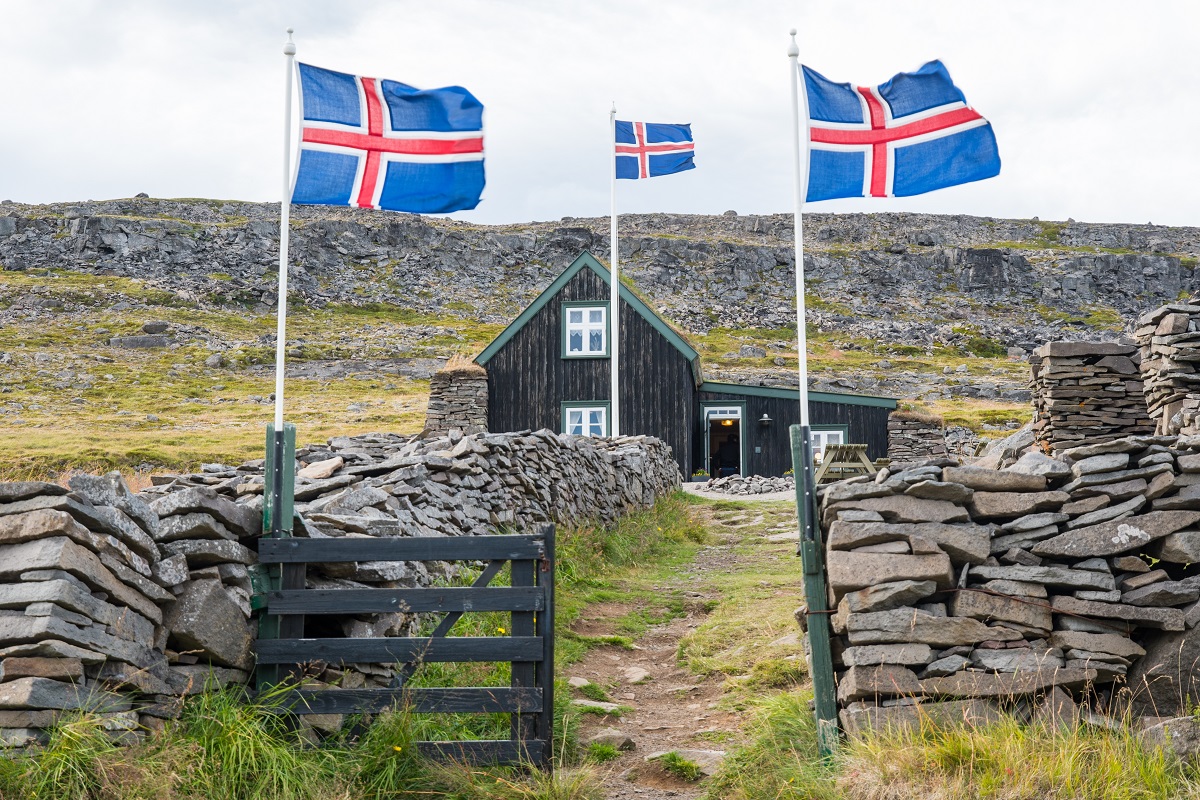 IJslandse vlaggen hangen buiten  bij de Litlibaer turfboerderij gelegen op de Westfjorden.